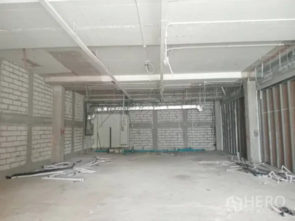 Retail Space for rent - Large shell retail interior with masonry walls, exposed ceiling ducts, and concrete floor.