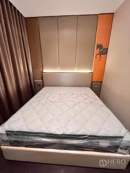 Condominium for rent in Watthana, Bangkok - Cozy bedroom featuring a padded headboard, warm lighting, and blackout curtains.