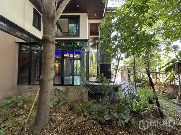 Detached House for sale in Lam Luk Ka, Pathum Thani - Glass-walled room overlooking leafy garden and water feature