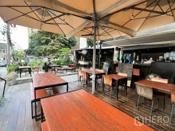 Retail Space for rent in Watthana, Bangkok - Outdoor dining terrace with wooden tables, large umbrellas and greenery at the streetfront.