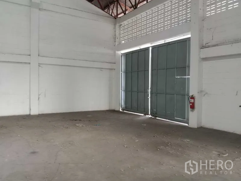 Factory for rent in Samut Prakan - Interior view to double steel doors with a fire extinguisher by the entrance.