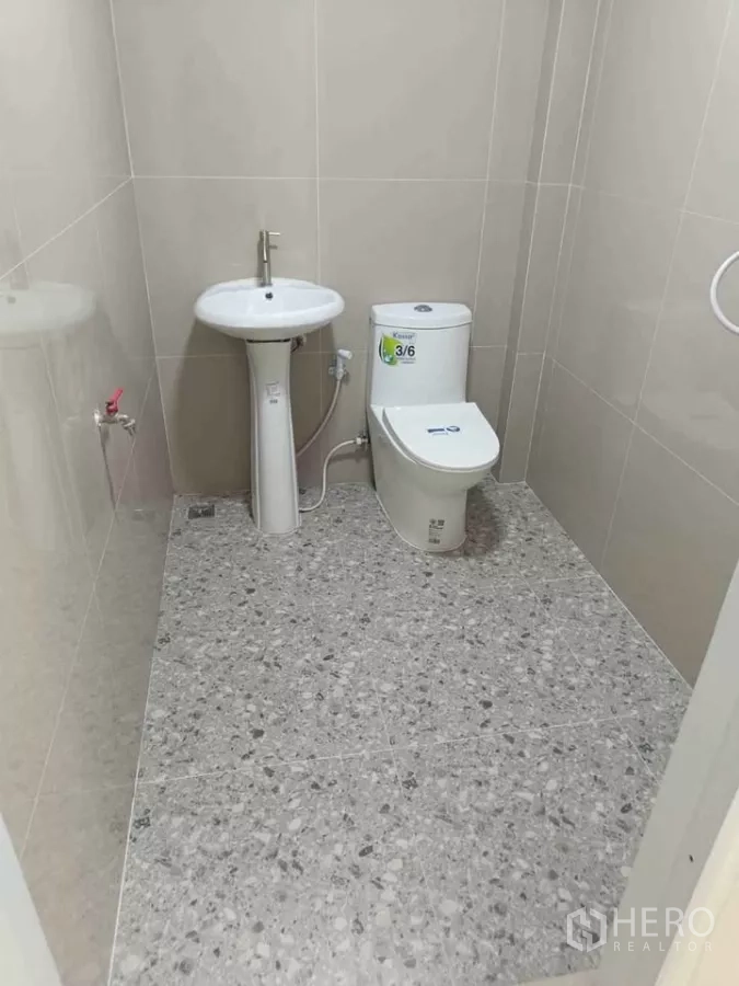 Home Office for rent in Bang Phli, Samut Prakan - Clean tiled bathroom with toilet, pedestal sink and handheld bidet.