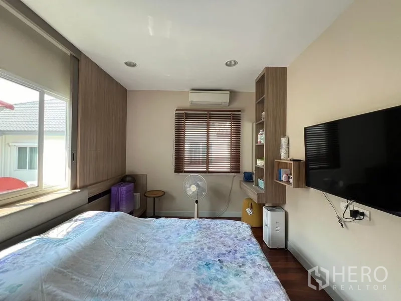 Detached House for rent or sale in Saphan Sung, Bangkok - Secondary bedroom with TV wall, shelving and natural light.