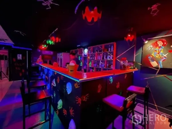 零售空间 出租在Watthana, Bangkok - 霓虹灯吧台，背柜陈列丰富，色彩装饰醒目。