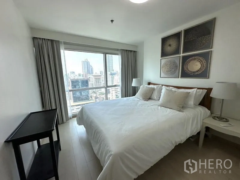 Condominium for rent or sale - Bedroom with king bed, wide window showcasing city views and contemporary wall art.