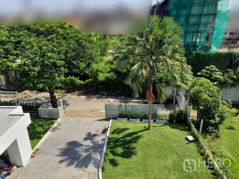 Detached House for rent in Phra Khanong, Bangkok - Aerial look at the gated entrance, palm and lawn inside the compound.