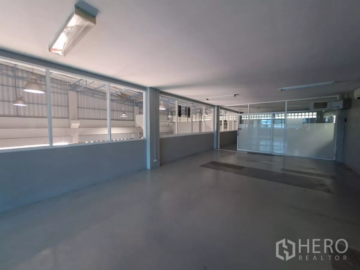 Warehouse for rent in Suan Luang, Bangkok - Large enclosed office space with sliding glass partitions and fluorescent lighting.
