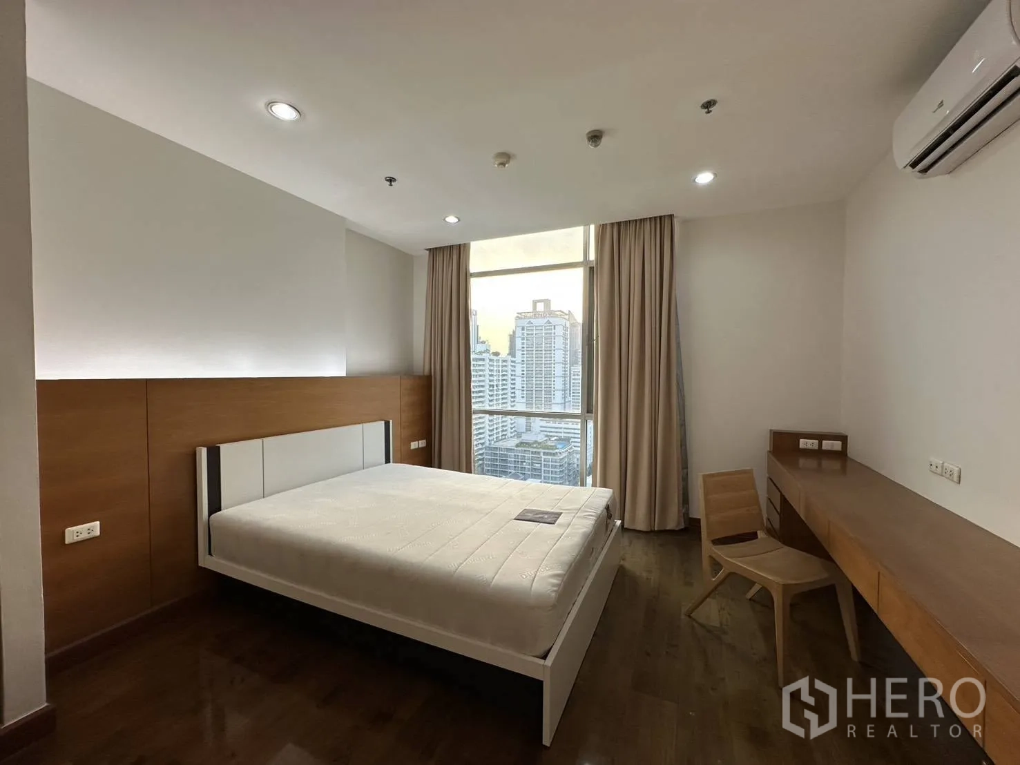 公寓 for rent in Watthana, Bangkok - 次卧带书桌、空调与大窗户，可观城市景观。