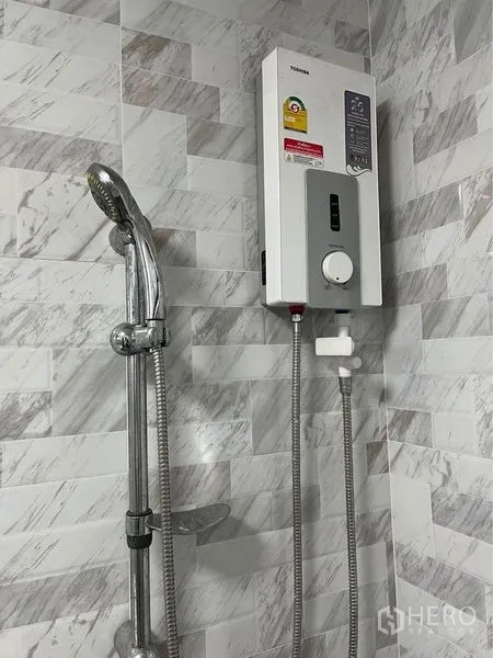 带办公室的家 出租在Bang Sue, Bangkok - 浴室内配手持花洒和电热水器，墙面为大理石纹瓷砖。