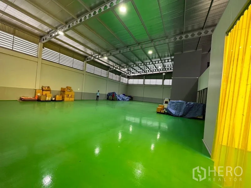 工厂 出租或出售在Lam Luk Ka, Pathum Thani - 大型仓储区，黄色软帘入口，高挑屋顶与光亮地坪。