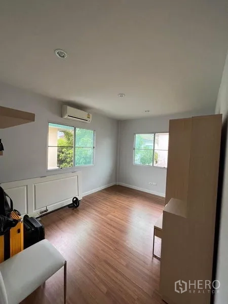 Detached House for sale in Bang Kruai, Nonthaburi - Bright multipurpose room with wood flooring, two windows, air conditioner and cabinet.