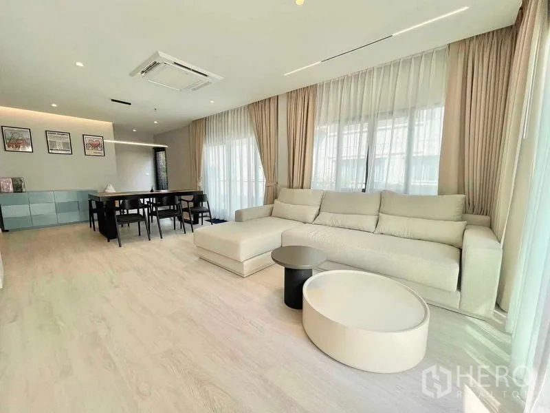 บ้าน ให้เช่าในBang Phli, Samut Prakan - ห้องนั่งเล่นเชื่อมทานอาหาร โซฟา L หน้าต่างสูงเต็มผนัง พื้นไม้โทนอ่อน