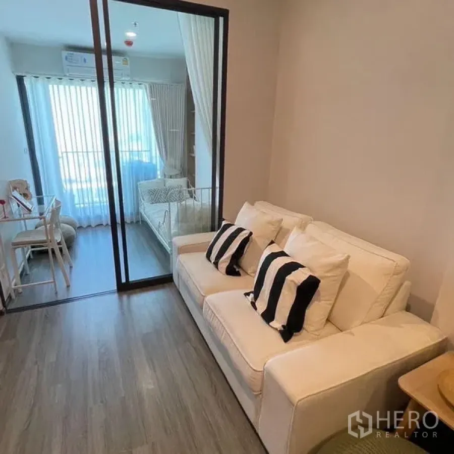 Condominium for rent - Another angle of the cozy living area with sofa and glass partition to the sunlit room.