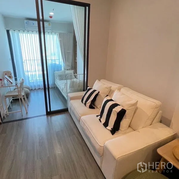 Condominium for rent - Another angle of the cozy living area with sofa and glass partition to the sunlit room.