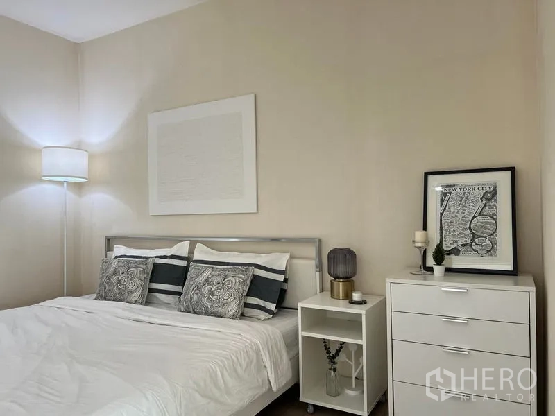 Condominium for rent in Khlong Toei, Bangkok - Cozy bedroom with white bedding, bedside tables and a dresser.