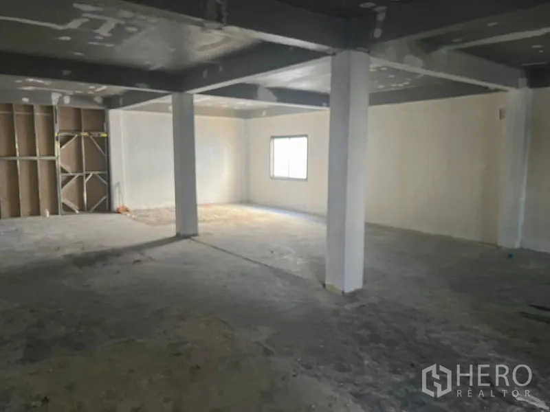 Retail Space for rent in Pathum Wan, Bangkok - Large open retail floor with partial partition wall and a single window.