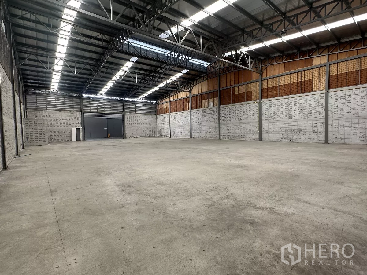 Warehouse for rent in Khlong Toei, Bangkok - High-ceiling warehouse showing loading doors, ventilated upper walls and ample open floor area.