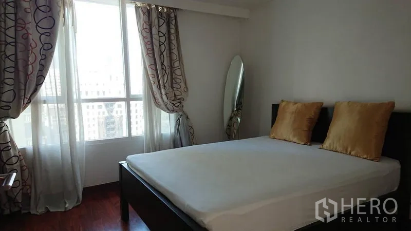 公寓 出租在Pathum Wan, Bangkok - 客卧配金色抱枕、立式镜子与纱帘，窗边采光良好。