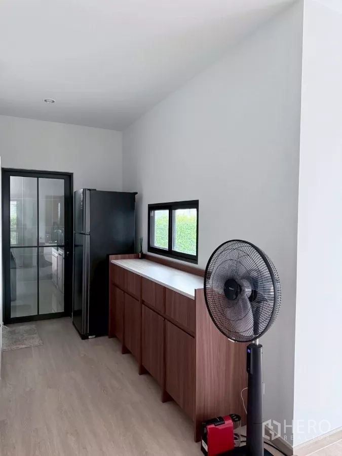 Detached House for rent in Lat Krabang, Bangkok - Pantry area with tall cabinets, refrigerator and sliding glass door to kitchen.