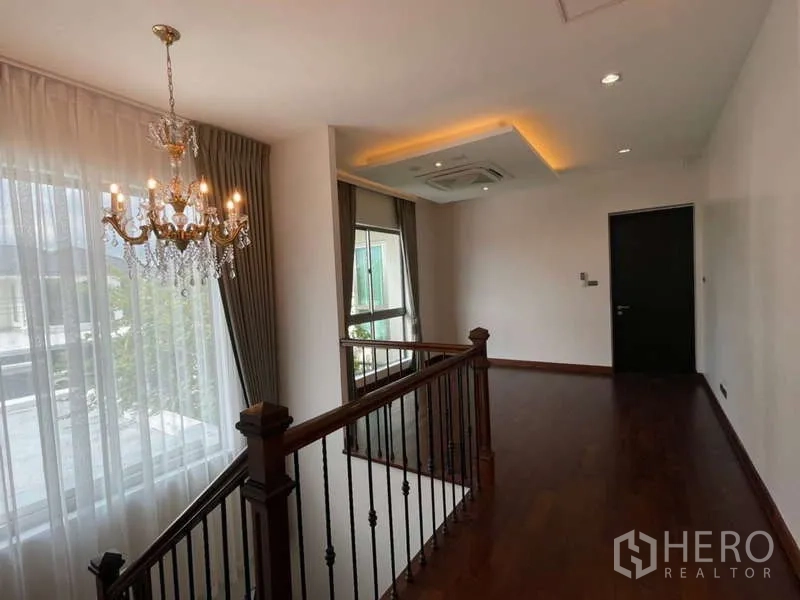 Detached House for rent or sale in Lat Krabang, Bangkok - Upstairs hallway with chandelier, wood floors and recessed lighting.