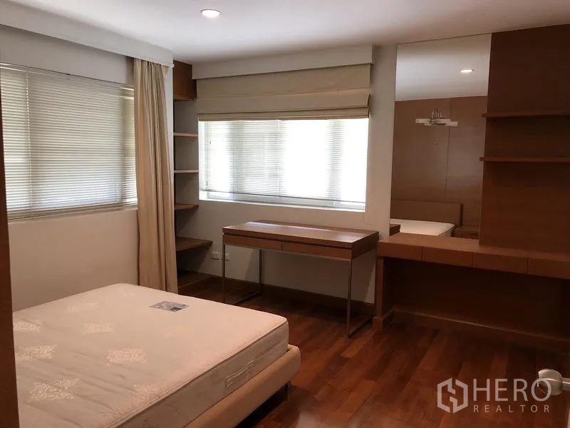 独立式住宅 出租在Watthana, Bangkok - 卧室配木地板，大窗，内置书桌与搁架。