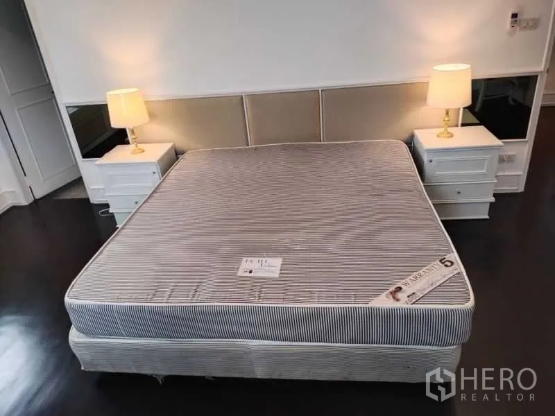 Condominium for rent in Sathon, Bangkok - Close view of upholstered headboard with bedside tables and lamps in the master bedroom.