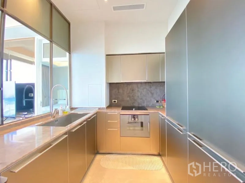 公寓 出租在Khlong San, Bangkok - 现代U型厨房，石材台面，嵌入式电器与充足收纳。