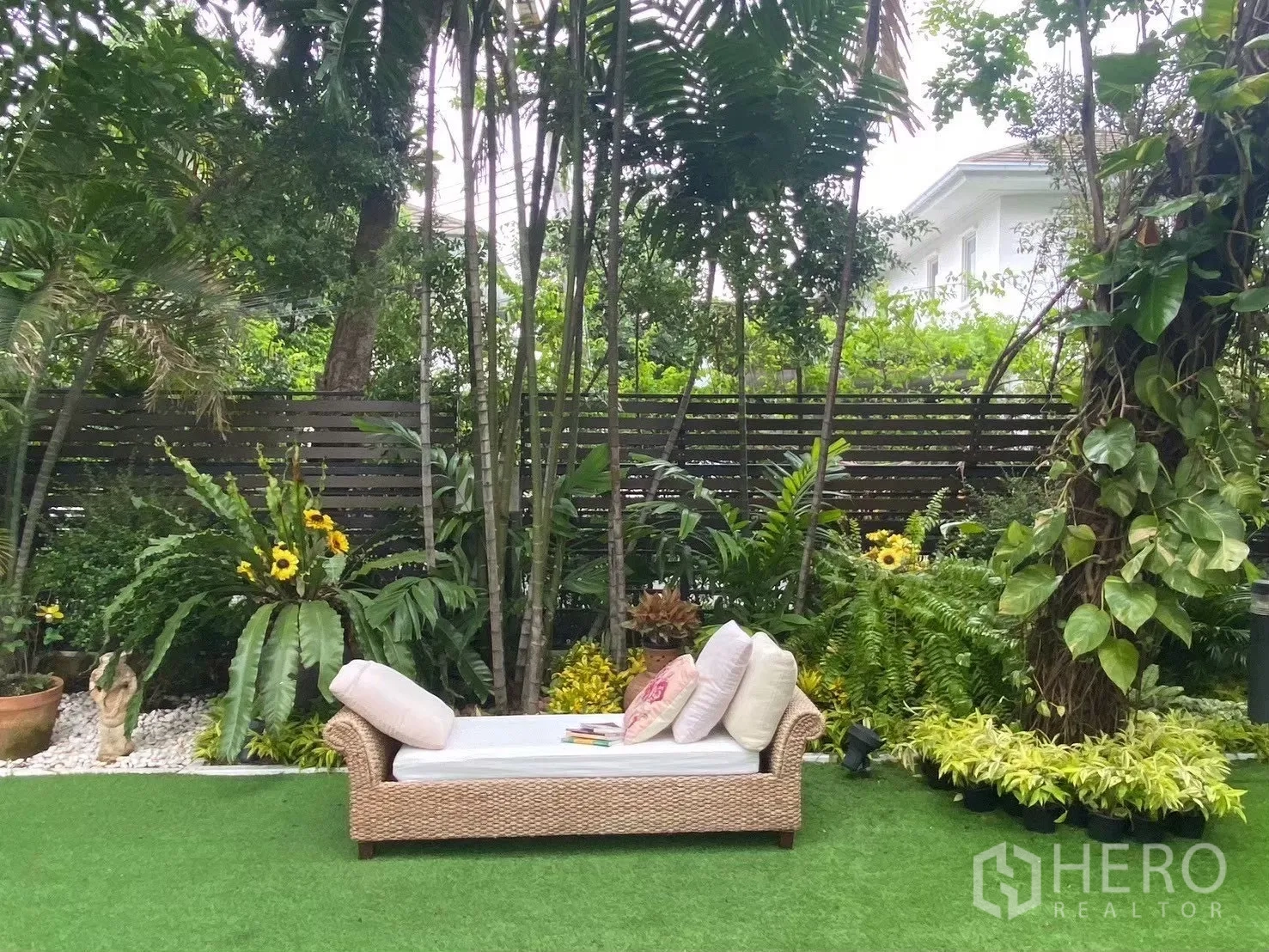 独栋房屋 for sale in Suan Luang, Bangkok - 户外贵妃躺椅置于人造草坪，周围环绕竹子与繁茂植被。