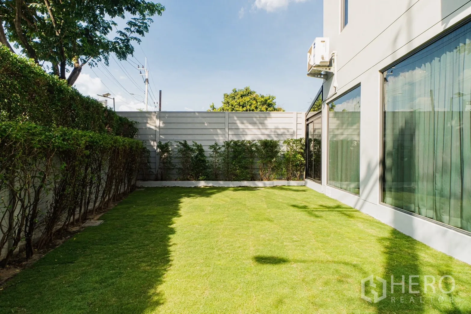 Detached House for rent or sale in Prawet, Bangkok - Fenced side garden with lawn bordered by hedges