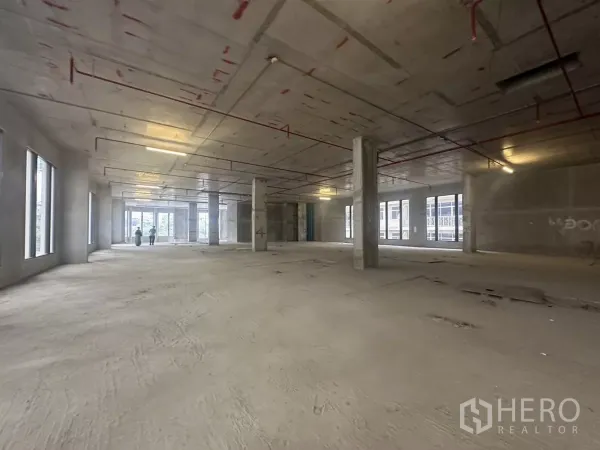 Retail Space for rent in Watthana, Bangkok - Large open retail level with red ceiling pipes and structural columns for flexible layouts.