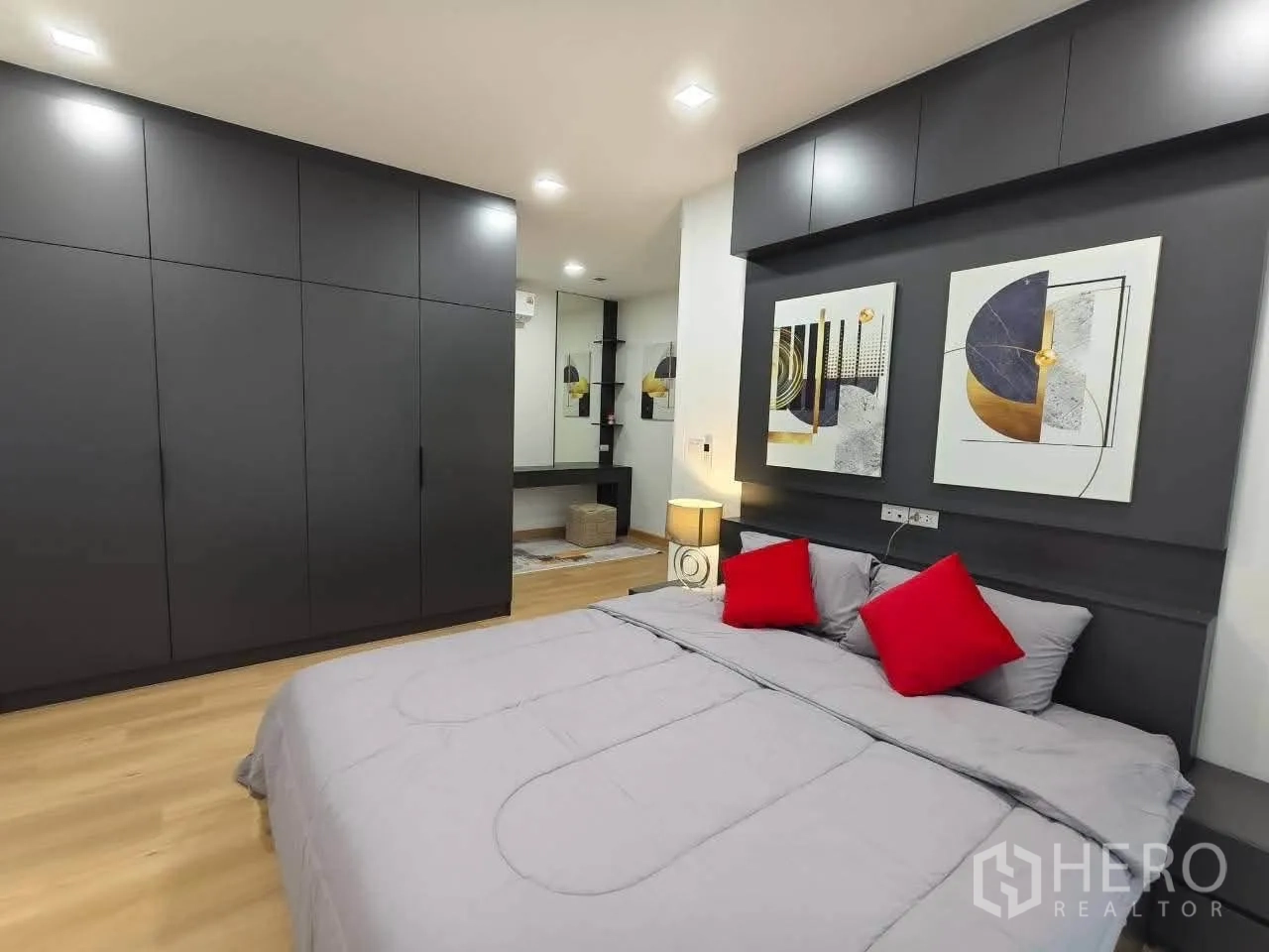 บ้านเดี่ยว for rent in Bang Phli, Samut Prakan - ห้องนอนติดตั้งตู้เสื้อผ้าบิวท์อินสีเทาและเตียงพร้อมหมอนสีแดง.