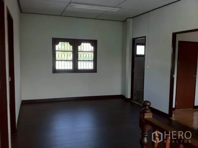 Warehouse for rent in Lam Luk Ka, Pathum Thani - Spacious upper room with grilled windows and a doorway leading to a bathroom.