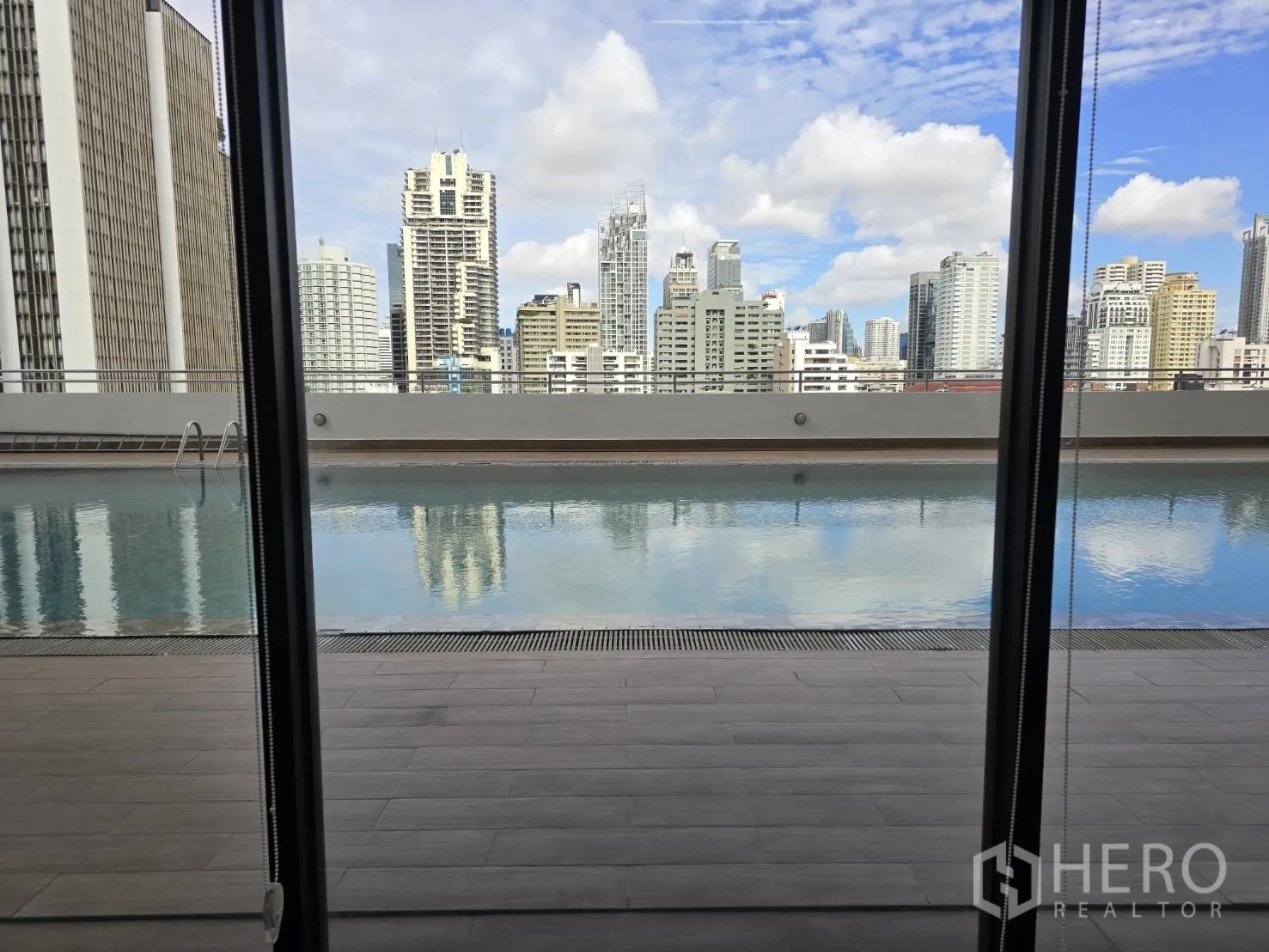 ออฟฟิศ for rent in Watthana, Bangkok - สระว่ายน้ำดาดฟ้าและเส้นขอบฟ้าเมืองมองผ่านกระจกเต็มบาน.