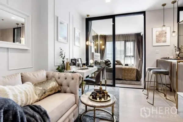 Condominium for sale in Pathum Wan, Bangkok - Bright living room with sofa, glass partition to bedroom and chic bar counter.