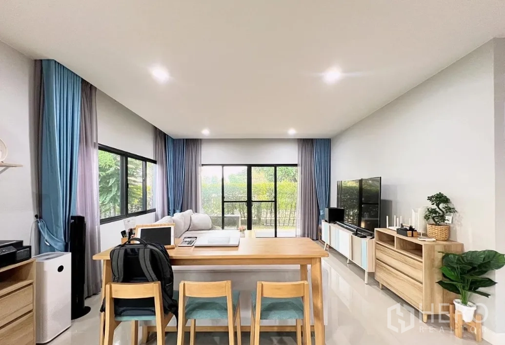 Detached House for rent or sale in Lam Luk Ka, Pathum Thani - Open living and dining space facing garden through sliding glass doors.