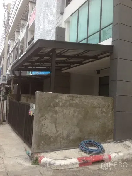 Home Office for rent in Bang Phli, Samut Prakan - Side exterior of a townhouse-style commercial building with canopy roof and boundary wall.