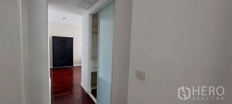 公寓 出租在Pathum Wan, Bangkok - 走廊配滑门衣柜与木地板，通向卧室的曼谷公寓内部。