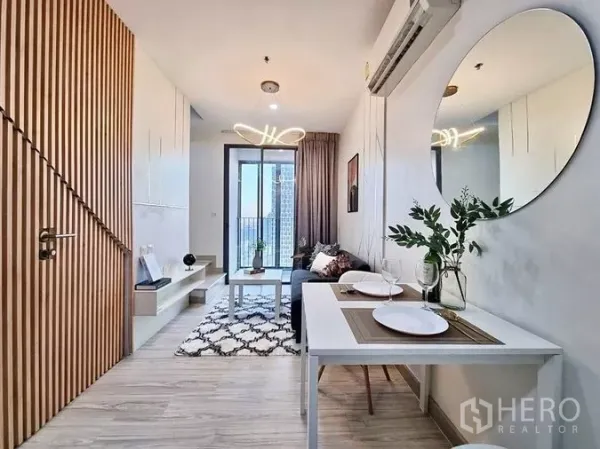 公寓 出售在Phra Khanong, Bangkok - 开放式客餐厅，圆镜与木质饰面，直通阳台。