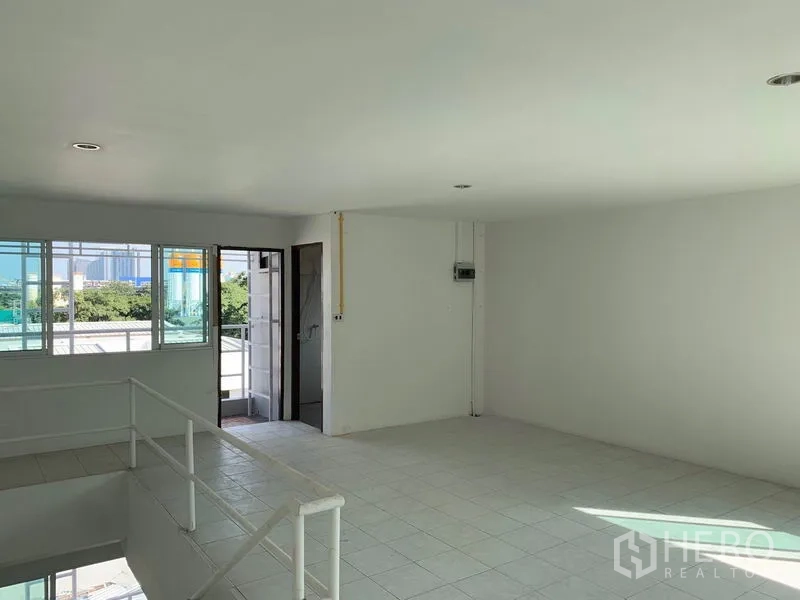 Office Space for rent in Huai Khwang, Bangkok - Bright office room with windows, a small balcony door and tiled flooring.