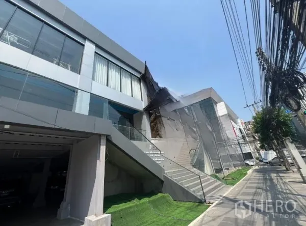 Retail Space for rent in Huai Khwang, Bangkok - Modern multi-level retail building with large glass facade, street-facing staircase and wide sidewalk in Huai Khwang.