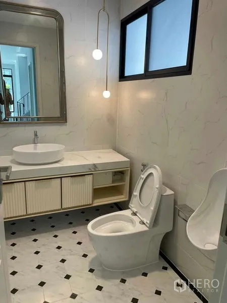 Detached House for sale in Saphan Sung, Bangkok - Guest bathroom with marble vanity, large mirror, and patterned floor tiles.