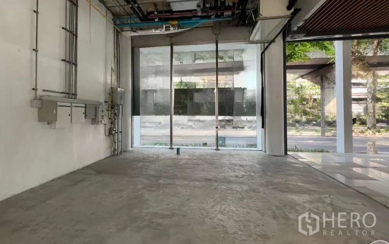 Retail Space for rent in Phaya Thai, Bangkok - Empty ground-floor retail unit with concrete floor, exposed ceiling services, and full-height glass frontage facing the street in Phaya Thai.