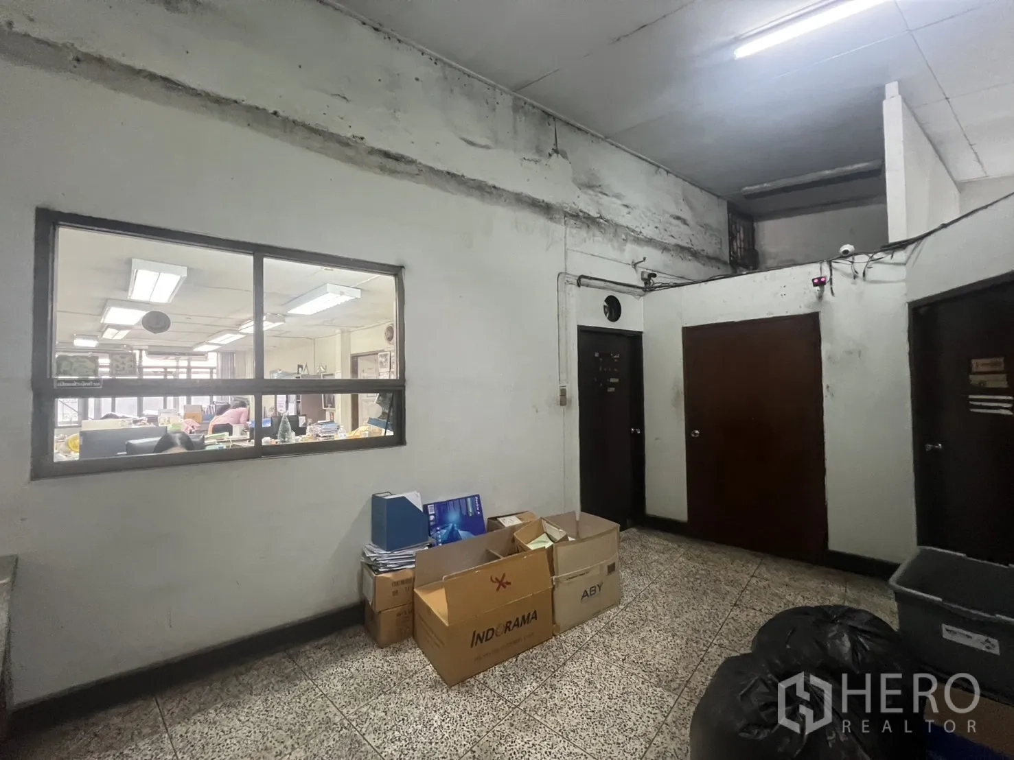 店屋 出租 - 公共区域，放置纸箱，带窗户与多扇门。