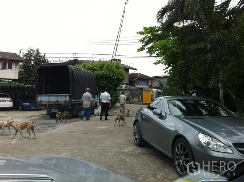 Factory for rent in Khlong San, Bangkok - Wide concrete driveway with truck and cars beside trees at a factory compound in Khlong San.
