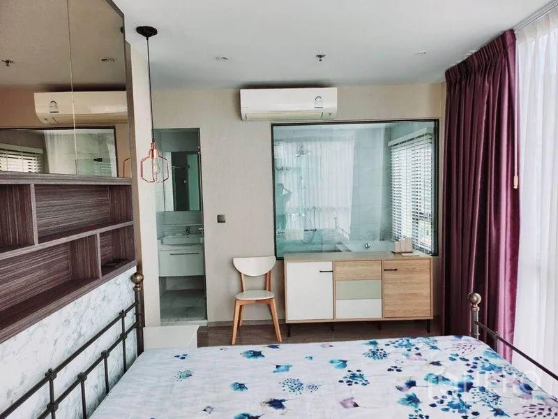 公寓 出租在Watthana, Bangkok - 主卧与带浴缸的套内卫浴以玻璃相连，配空调与全高窗帘。