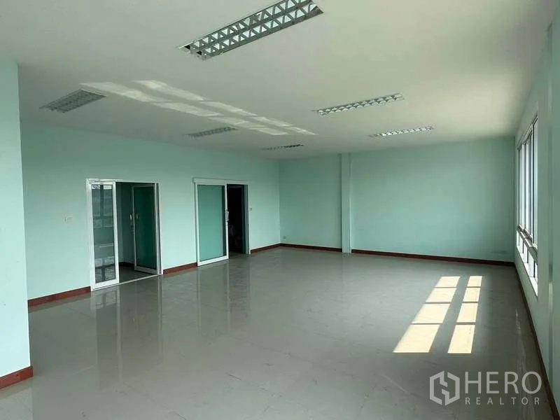 Warehouse for rent in Bang Phli, Samut Prakan - Bright office space with tiled floors, large windows and fluorescent ceiling lights.