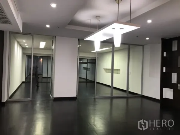 公寓 出租在Watthana, Bangkok - 宽敞开放空间，深色地板、嵌灯与玻璃隔断房间。