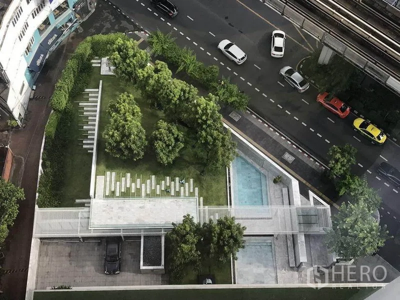Condominium for rent in Khlong Toei, Bangkok - Aerial view of condo landscaped garden and pool beside road and BTS line