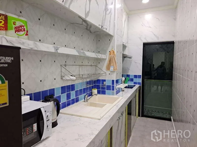 公寓 出租在Khlong Toei, Bangkok - 厨房水槽区通向带推拉门的生活阳台。