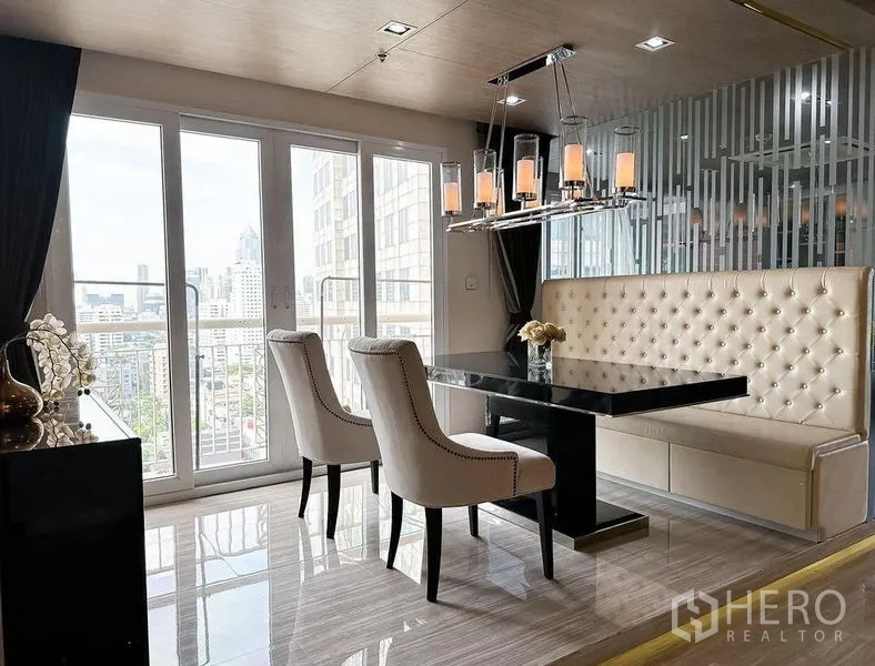 公寓 出租或出售在Khlong Toei, Bangkok - 带纽扣软包卡座的用餐角，黑色餐桌与阳台落地门。